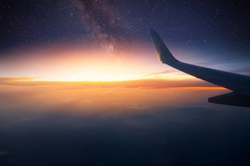The empennage of the plane flying over a sunset 
