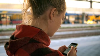 close up of young woman using smartphone outdoors by street