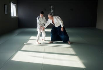 adolescent learning defensive martial arts movement with his sensei