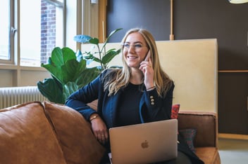 business woman talking on phone with laptop in lap
